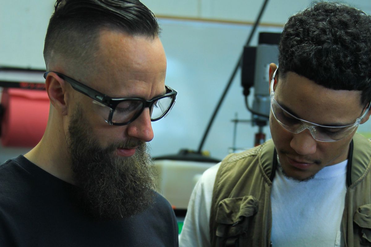 Two technicians inspecting a finished cast polyurethane spring insert